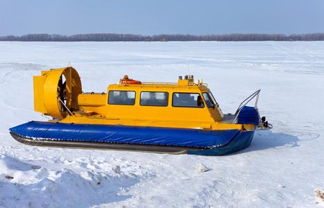 气垫船在冰封的河流的银行照片
